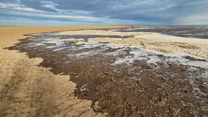 Lake Eyre dry salt flat landscape with cloudy blue sky