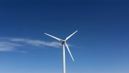 Single wind turbine against clear blue sky.