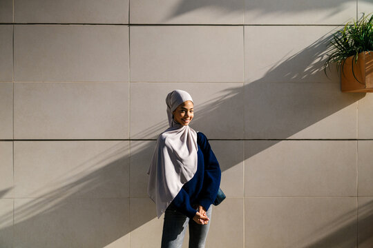 Young muslim woman smiling outdoors in sunlight