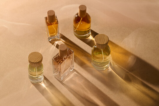 Elegant perfume bottles with wooden caps on a neutral background