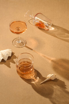 Elegant cocktail glasses with shadows and seashells