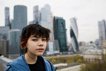 Young person with headphones looking at the city skyline