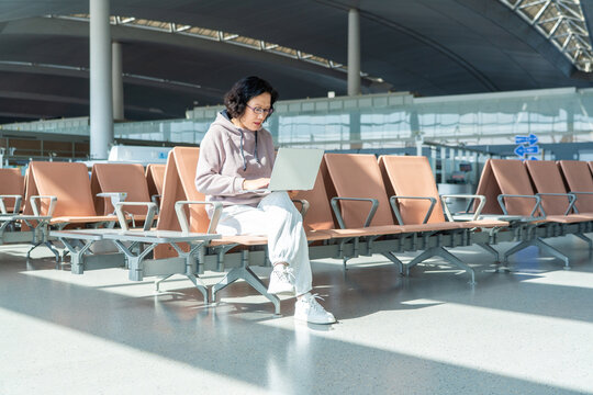 woman working on laptop in airport terminal
