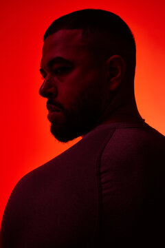 Strong silhouette of a man with red background highlighting feat