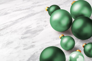 Green Christmas ball ornaments on white marble table, holiday background