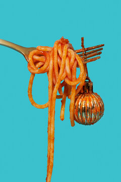 a dangling Christmas bauble beside hanging spaghetti strands