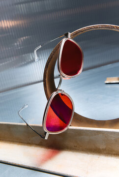 Sunglasses Resting On Rusty Metal Ring With Red Lenses 