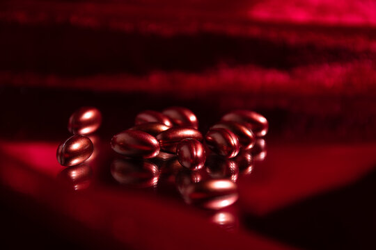 Vitamin capsules on mirror and velvet fabric