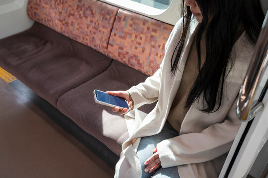 Woman Using Smartphone While Riding Train