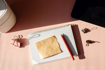 Above view of office desk with notes, laptop and pen.