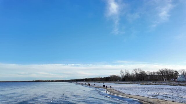 Winter coastal scenery at the Baltic Sea in Boltenhagen, Germany, filmed in January. The video shows a snowy beach with people walking along the shoreline under a dramatic winter sky.