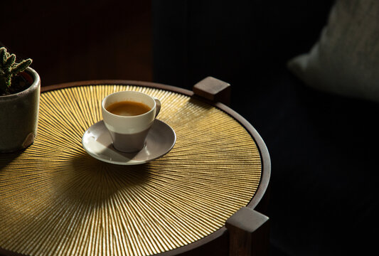 Coffee on a textured brass table.