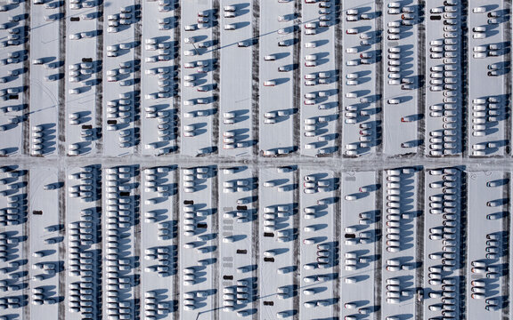 Snow-covered Parking Lot Filled With Parked Vehicles During Winter