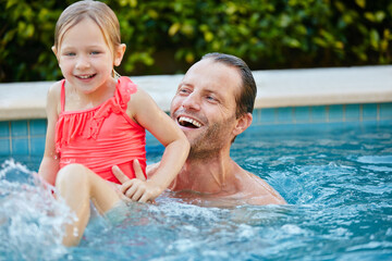 Happy dad, kid and swimming in pool for playful holiday, weekend or outdoor summer break. Father, child or playing with daughter or girl in water for bonding, fun childhood or aqua safety in backyard
