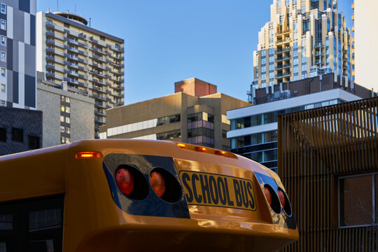 School Bus in Front of Urban High-Rise Buildings