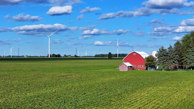 Wide Farmland with Red Barn and Wind Turbines near Ithaca, Michigan, USA in Aerial View