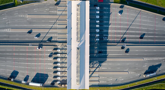 Busy Toll Plaza With Many Vehicles Traveling During Daylight Hours