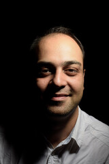 Obraz premium Portrait of an Iranian man with a simple smile on a black background