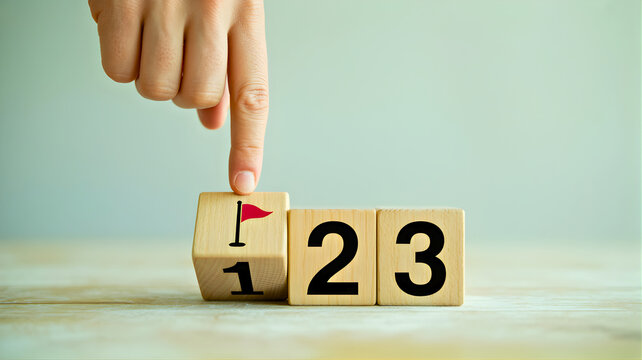 Hand placing a flag on the '1' block, representing the first step in achieving a goal, setting priorities, or marking progress in a strategic plan or personal development journey