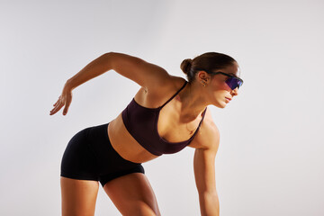 Woman in sportswear demonstrating athletic movement indoors