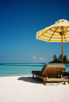 Beach Lounge Under Striped Umbrella