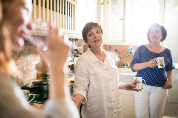 Mother talking with daughter in sunny home kitchen