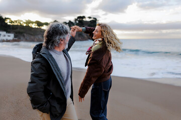 Couple joyfully dancing together on beach