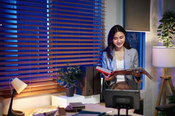 Interior designer reviewing material catalog in a modern home office at night