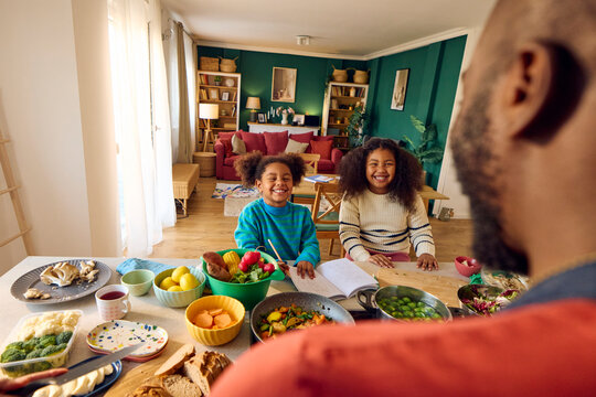 Girls spending fun time with their father in the kitchen