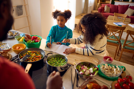 Girls spending time with their father in the kitchen