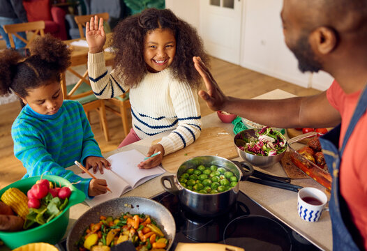 Children enjoying time with their dad in the kitchen
