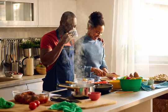 Couple shares joyful smiles in a cozy kitchen 
