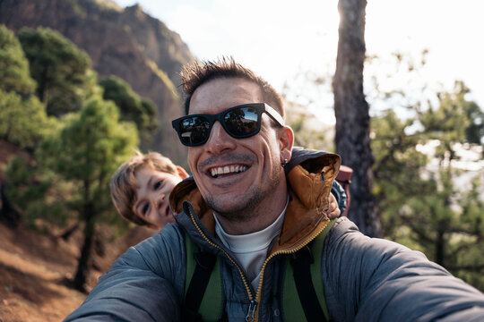 Father and son taking a selfie while hiking