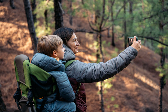 Mother and son taking selfie during forest hike