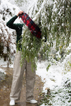 Fashion Model with Striped Scarf Wrapped Around Winter Branches