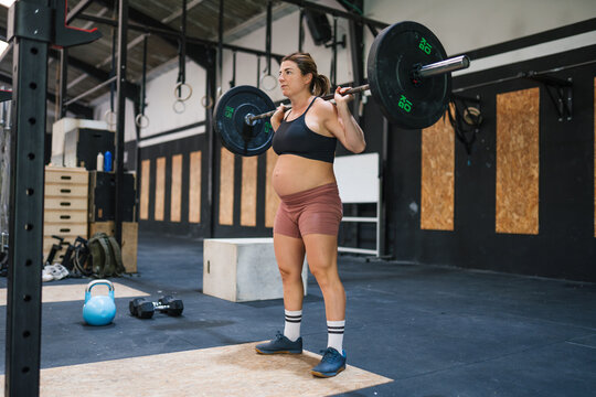 Pregnant woman weightlifting during functional training workout