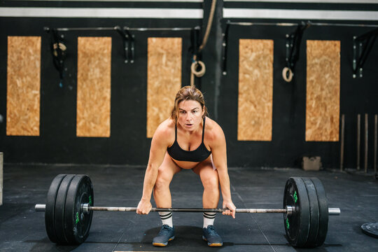 Pregnant woman performing deadlift during functional training session