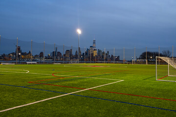 Urban football stadium overlooking Manhattan and the New York City skyline. Soccer field in a city...