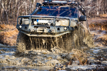 Offroad vehicle pushes through deep mud as it drives forward. Offroad driving extreme terrain. Offroad action in muddy conditions. Offroad adventure proves it can survive harsh trails. © Volodymyr