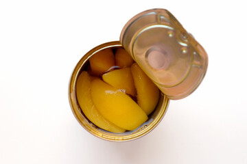 Canned yellow peaches. A can of yellow peach compote is open.