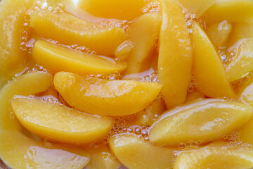 Close-up of sliced ​​yellow peaches marinated in syrup. Canned peaches.