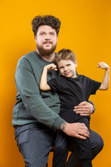 Family Father Love Concepts. Young Funny Smiling Cheerful Parent Dad with Boy Child In Casual Clothing While playing With Lifted Hands Huggin Cuddle Looking Straight Isolated