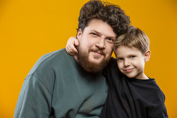 Family Father Love Concepts. Closeup Portrait of Young Funny Smiling Cheerful Parent Dad with Boy Child In Casual Clothing While playing With Lifted Hands Huggin Cuddle Looking Straight Isolated