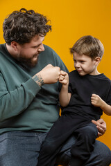 Father Love Concepts. Portrait of Young Funny Smiling Cheerful Playing Parent Dad with Boy Child In Casual Clothing With Lifted Hands Hugging Cuddle Looking Side Isolated
