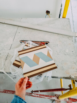 Worker holds colorful tiles on-site