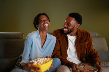 Enjoying a cozy movie night together with snacks at home
