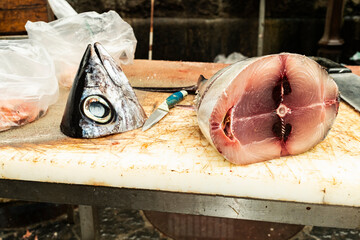 A tuna fish head lies beside a freshly cut section