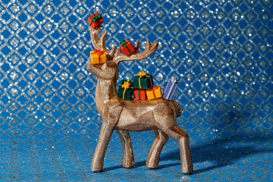 a glittered reindeer carrying colorful miniature gifts