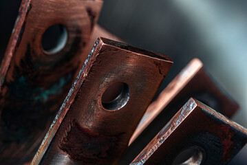 Oxidized coated copper busbars, non-ferrous metal products for the power industry, close-up view with industrial lighting
