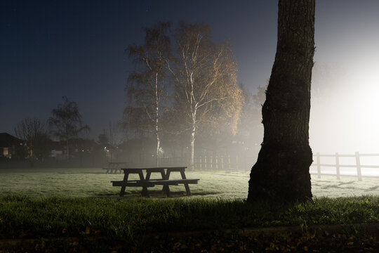 Picnic tables on a foggy winters night